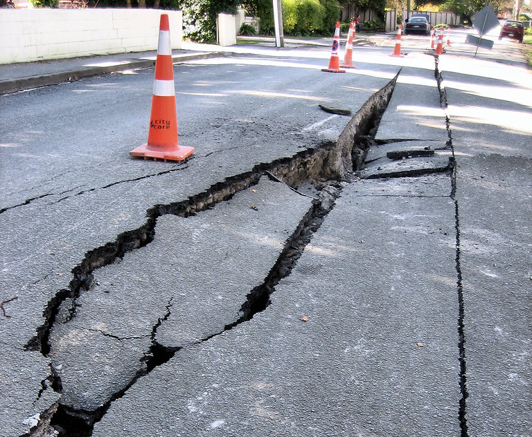 image of severely damaged and cracked road with pylons